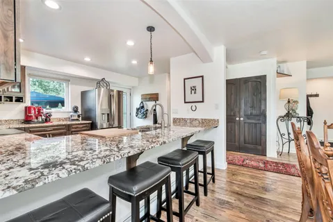 a view of a dining room and livingroom with furniture wooden floor a chandelier
