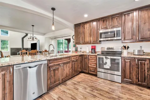 a kitchen with stainless steel appliances granite countertop a stove and cabinets