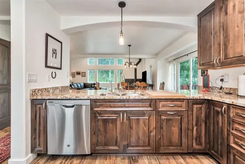 a kitchen with kitchen island granite countertop a sink cabinets and wooden floor