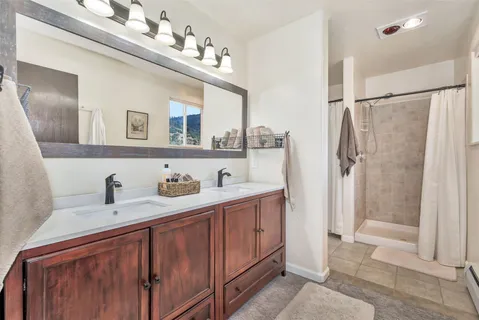 a bathroom with a double vanity sink and a mirror