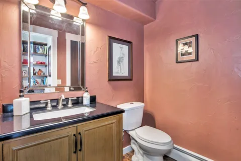 a bathroom with a toilet a sink and mirror