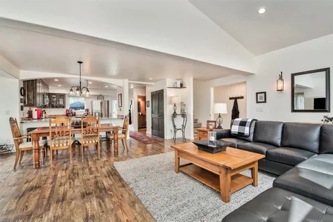 a living room with furniture wooden floor and a chandelier
