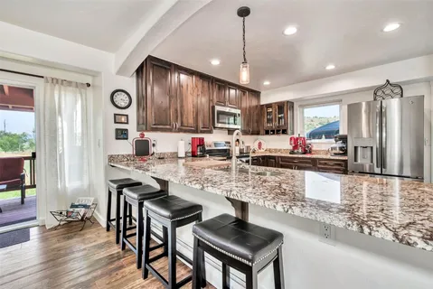 a kitchen with stainless steel appliances granite countertop a stove refrigerator and cabinets