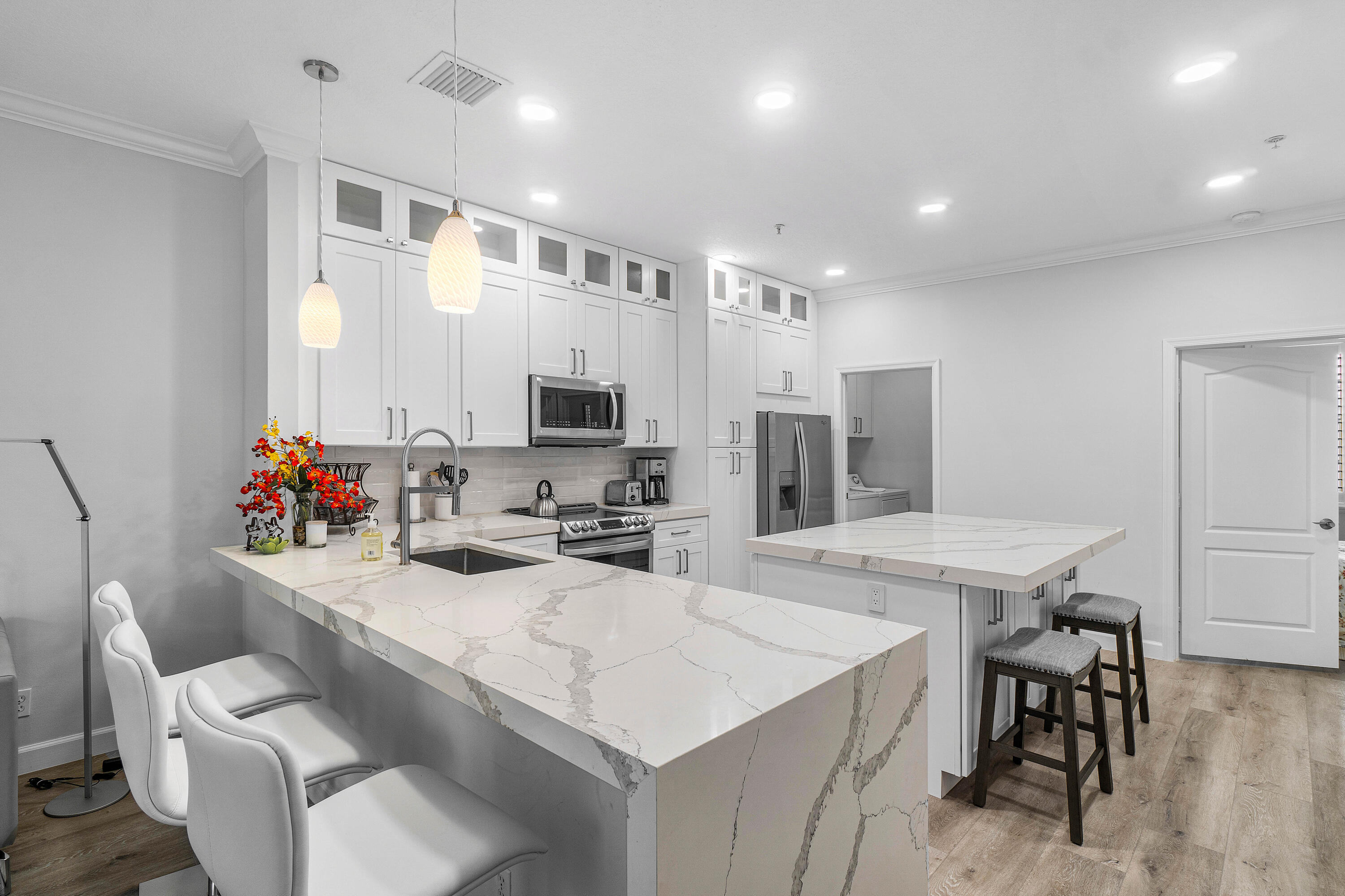 65 Southeast 5th Avenue, Unit B Delray Beach, FL 33483 - Photo 11 of 47 a kitchen with kitchen island a sink table and chairs