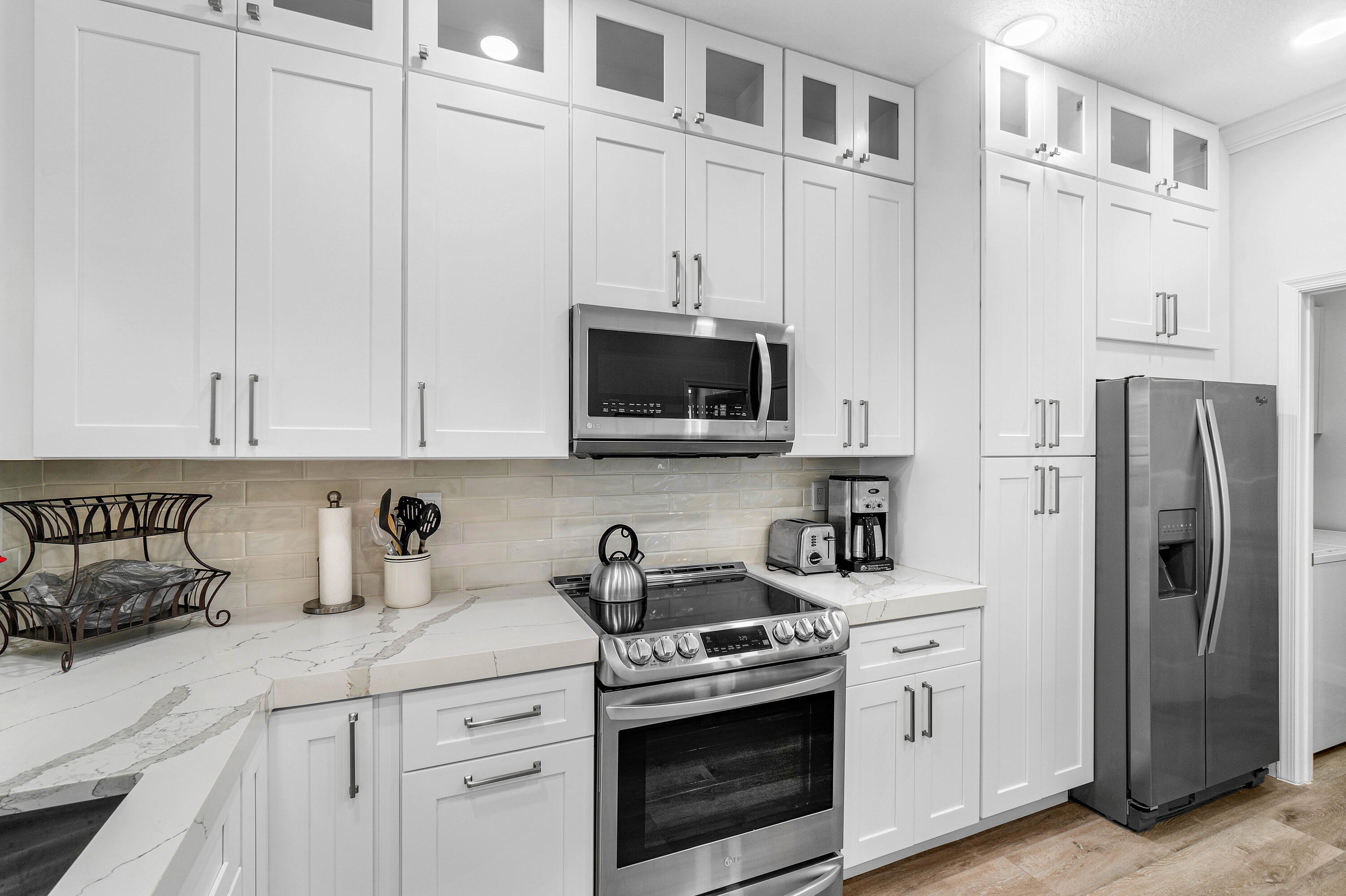 65 Southeast 5th Avenue, Unit B Delray Beach, FL 33483 - Photo 12 of 47 a kitchen with stainless steel appliances granite countertop white cabinets and a refrigerator