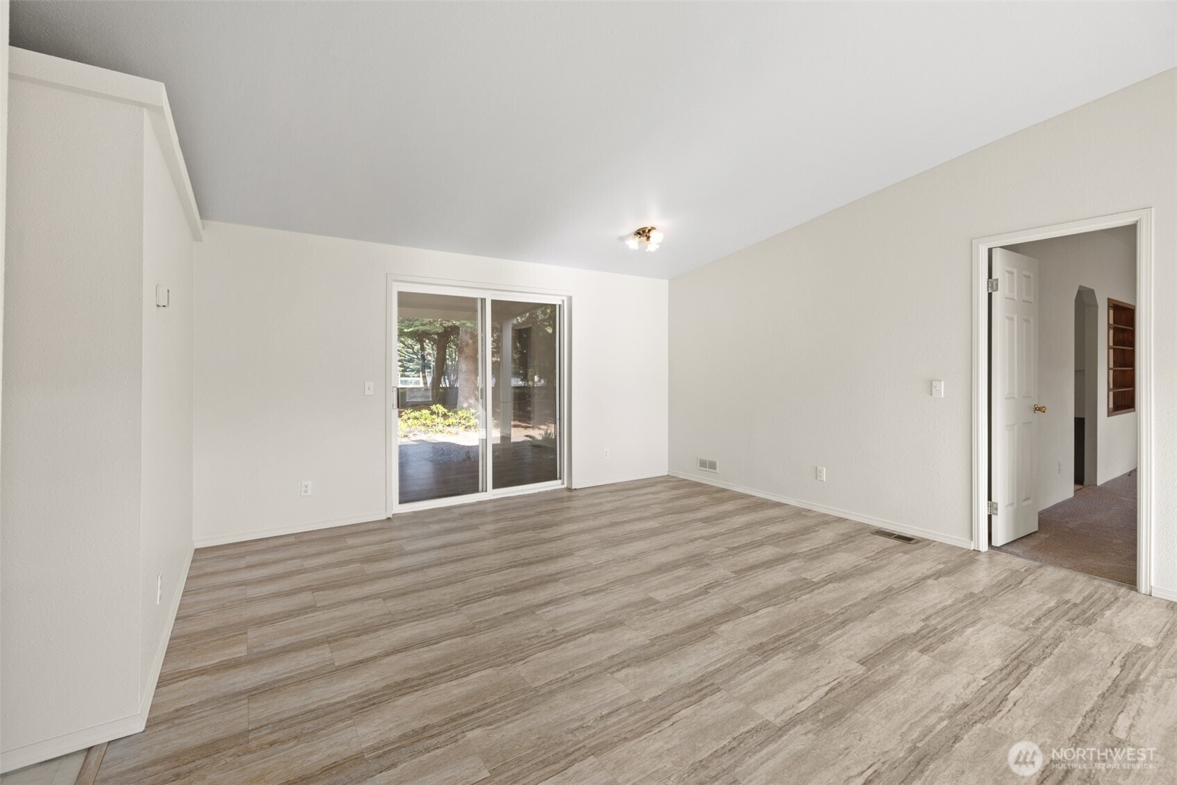 132 Cosmos Lane Port Angeles, WA 98362 - Photo 11 of 40 a view of an empty room with wooden floor and a window