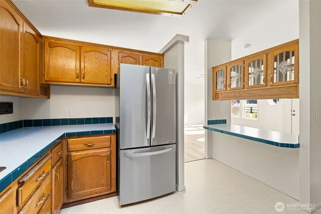 a kitchen with stainless steel appliances granite countertop a refrigerator a stove and a sink with cabinets