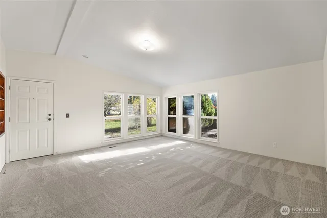 a view of a big room with windows and chandelier fan