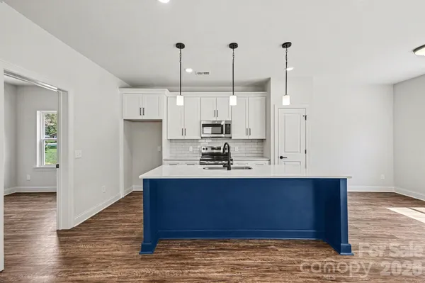 a view of kitchen with stainless steel appliances granite countertop cabinets and wooden floor
