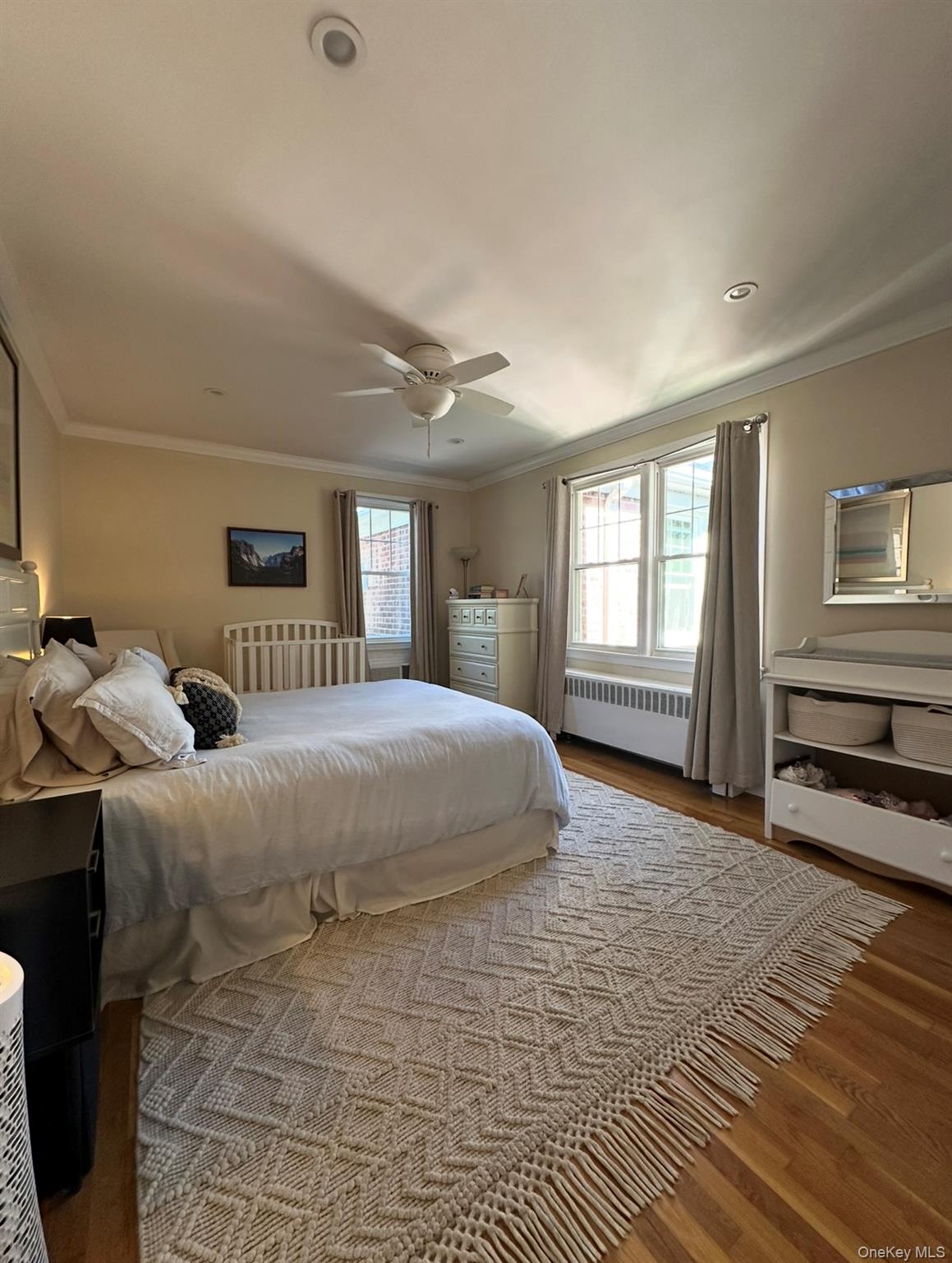 100 Cedar Street, Unit A21 Dobbs Ferry, NY 10522 - Photo 8 of 12 Bedroom with crown molding, wood finished floors, radiator, and a ceiling fan