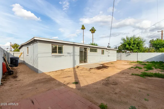 a backyard of a house with plants and outdoor seating