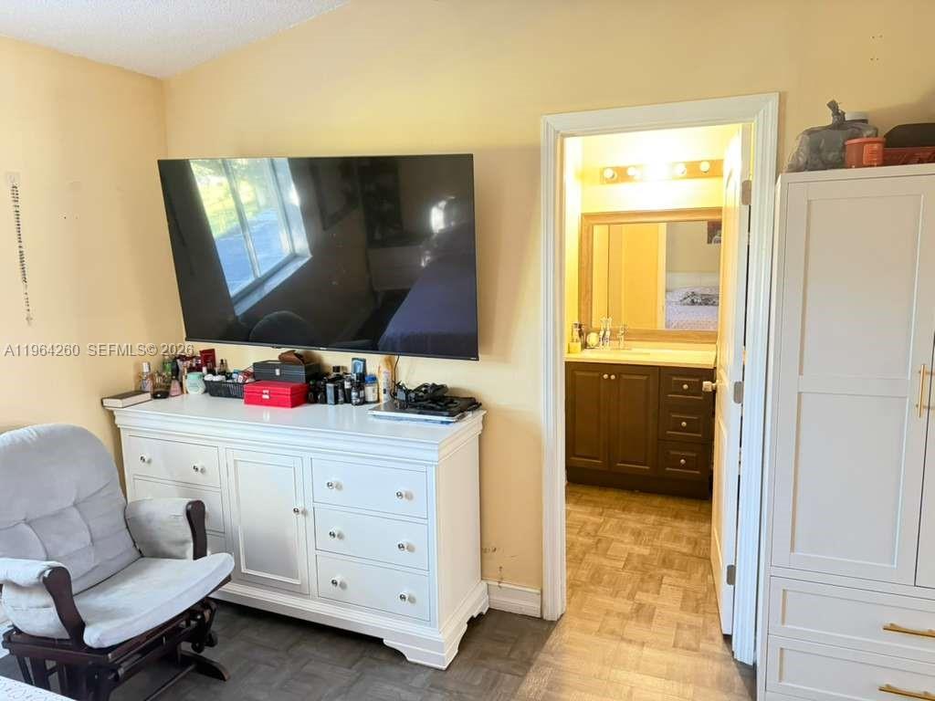 14012 Southwest 179th Street Miami, FL 33177 - Photo 14 of 17 a room with a chair and a flat screen tv