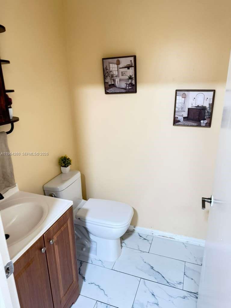 14012 Southwest 179th Street Miami, FL 33177 - Photo 15 of 17 a bathroom with a toilet sink and vanity