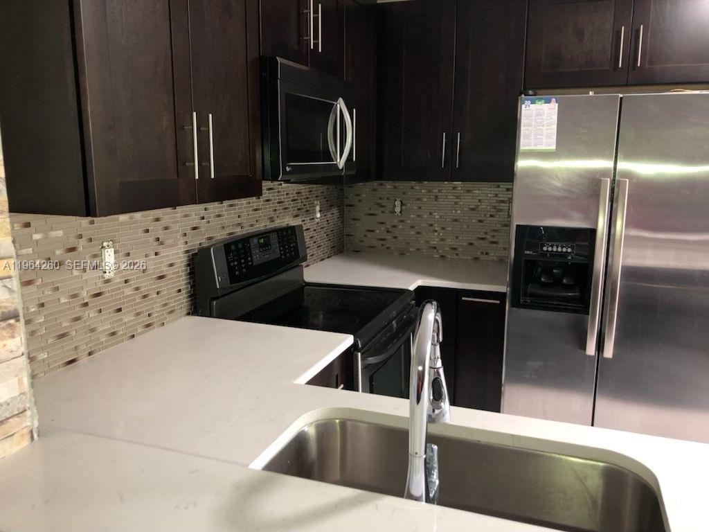 14012 Southwest 179th Street Miami, FL 33177 - Photo 6 of 17 a kitchen with stainless steel appliances kitchen island a sink stove and microwave