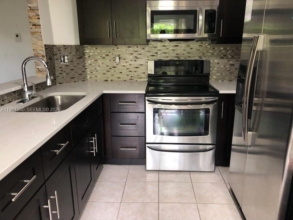 14012 Southwest 179th Street Miami, FL 33177 - Photo 7 of 17 a kitchen with a sink and stainless steel appliances