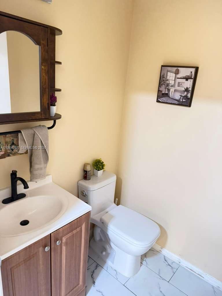 14012 Southwest 179th Street Miami, FL 33177 - Photo 8 of 17 a bathroom with a toilet a sink and mirror