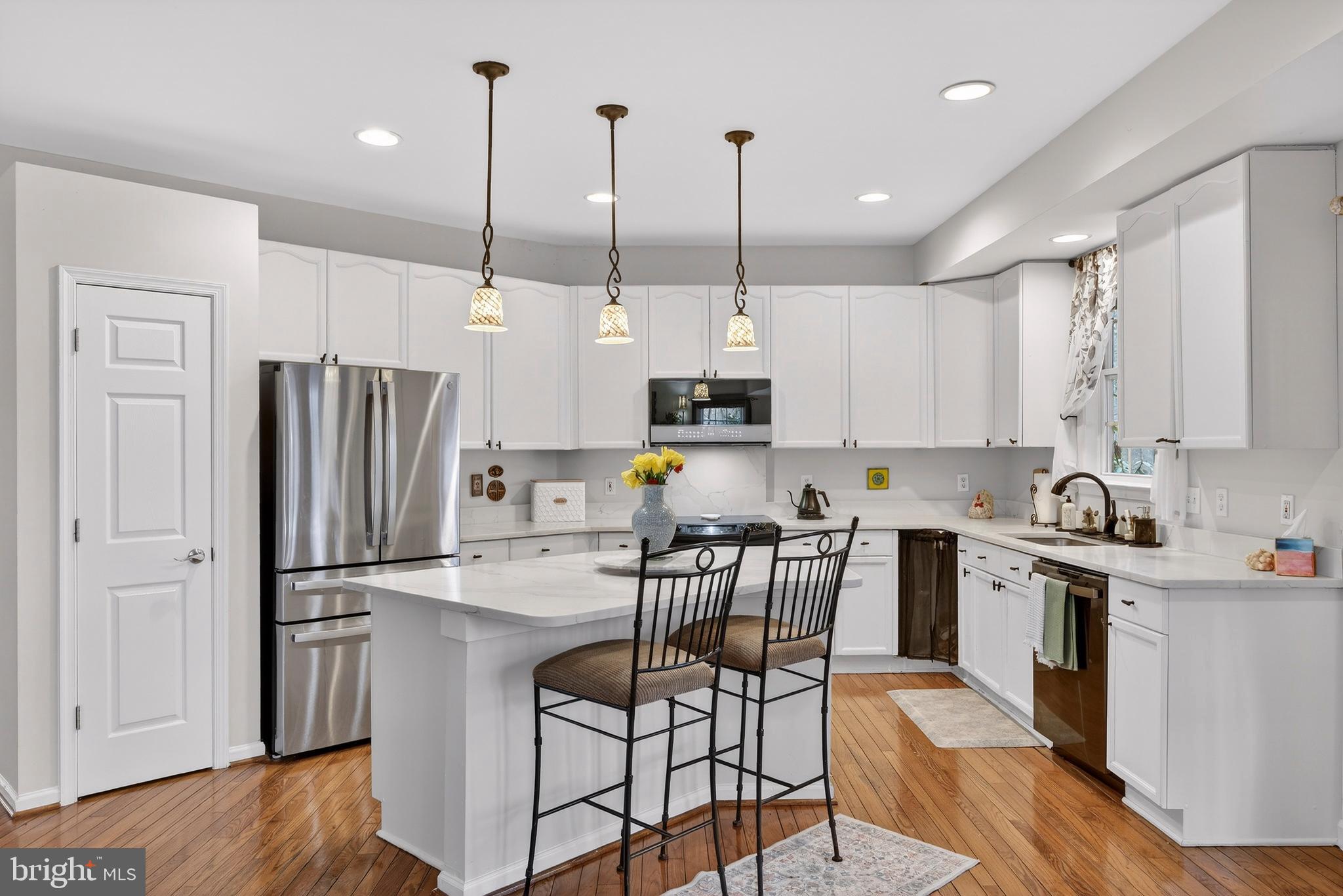 5777 White Rock Road Sykesville, MD 21784 - Photo 5 of 42 a kitchen with stainless steel appliances granite countertop a refrigerator a stove a sink dishwasher a dining table and chairs with wooden floor
