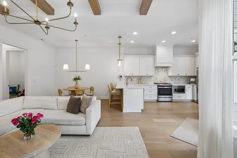 a living room with kitchen island furniture and a chandelier