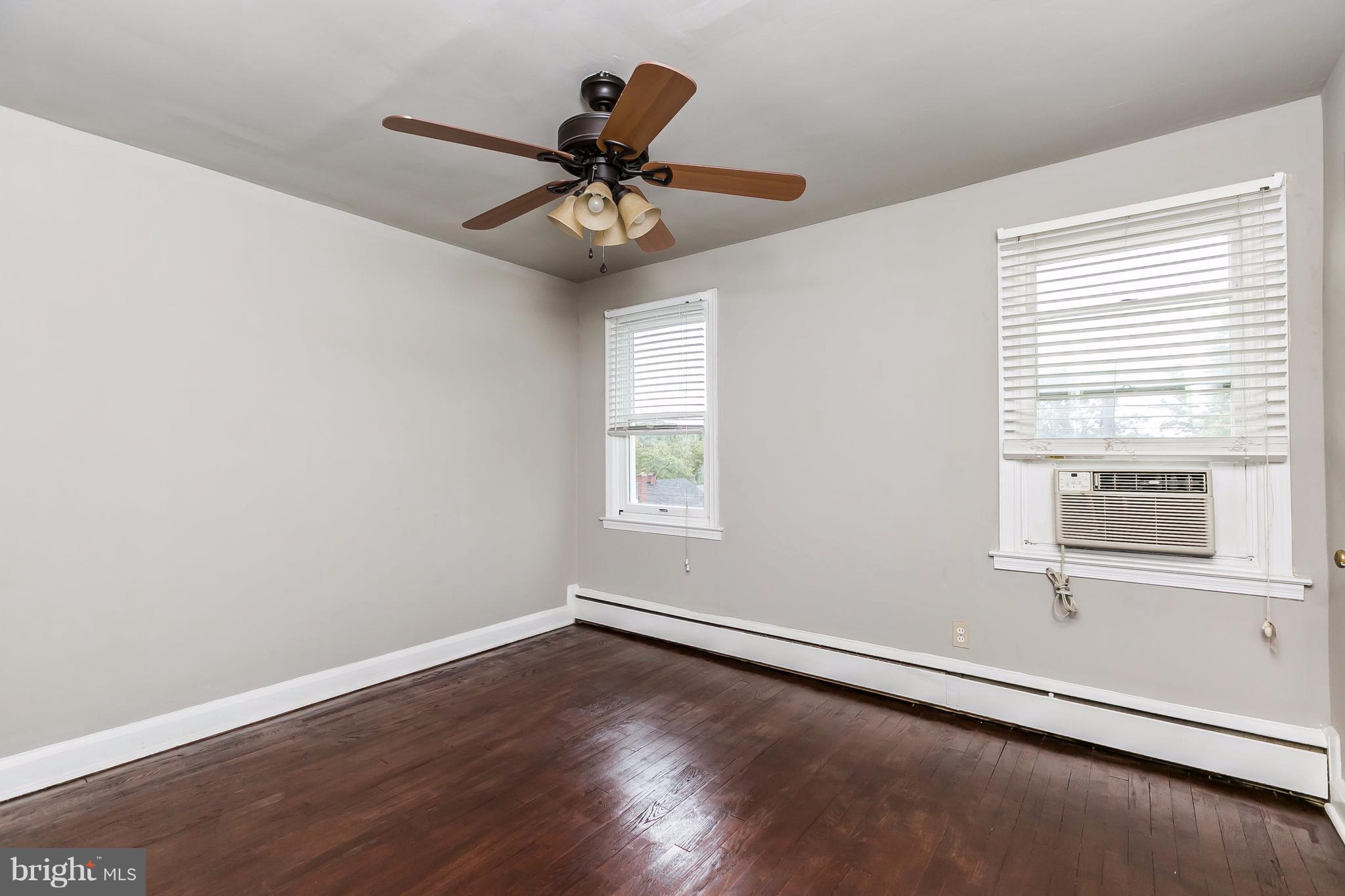 4016 Rexmere Road Baltimore, MD 21218 - Photo 15 of 26 an empty room with wooden floor fan and windows