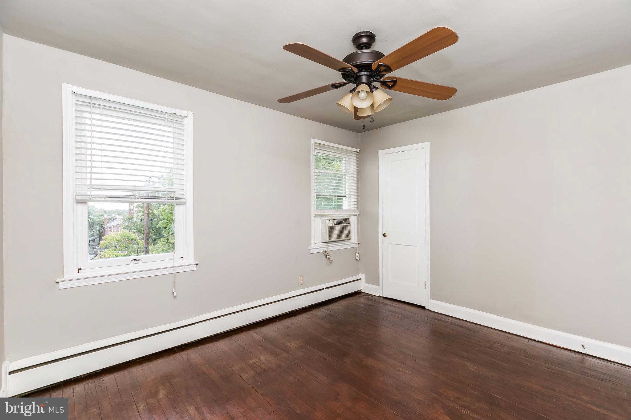 4016 Rexmere Road Baltimore, MD 21218 - Photo 16 of 26 an empty room with wooden floor fan and windows