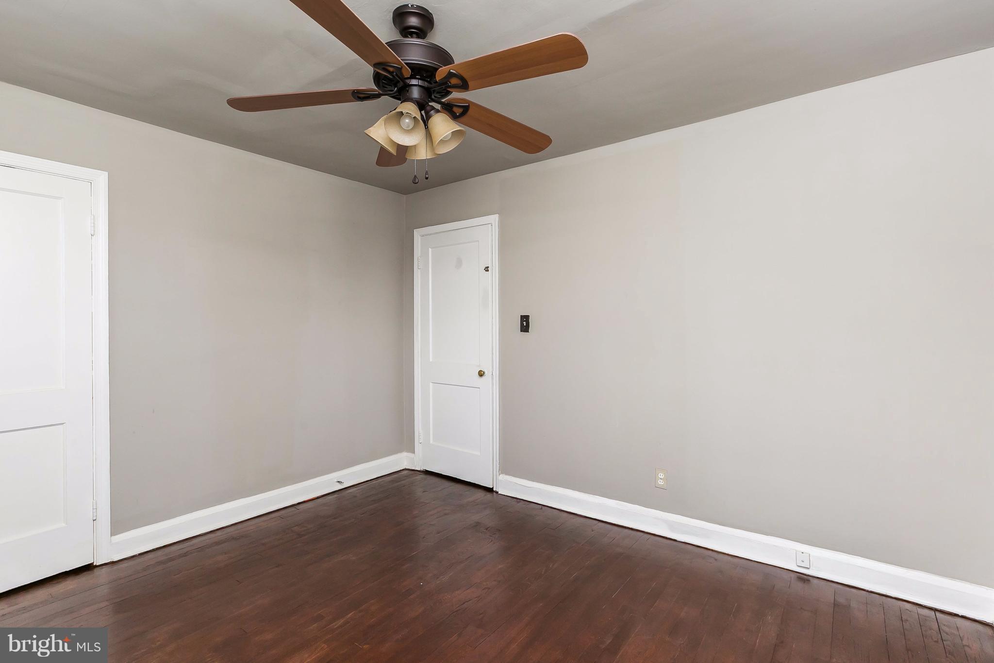 4016 Rexmere Road Baltimore, MD 21218 - Photo 17 of 26 an empty room with a ceiling fan and wooden floor