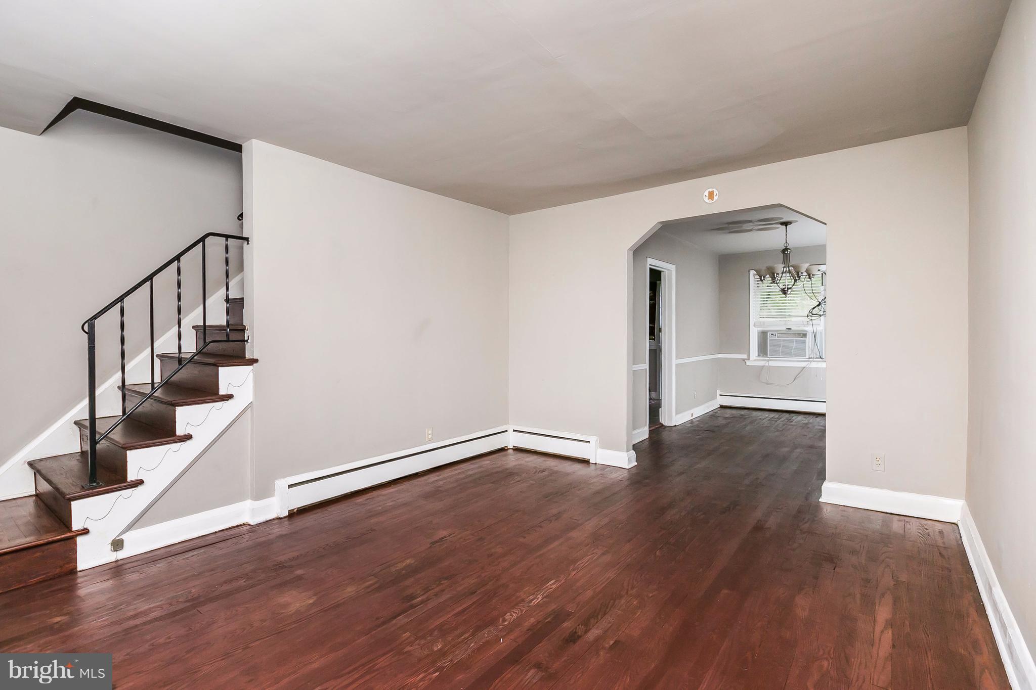 4016 Rexmere Road Baltimore, MD 21218 - Photo 3 of 26 a view of an empty room with wooden floor and stairs