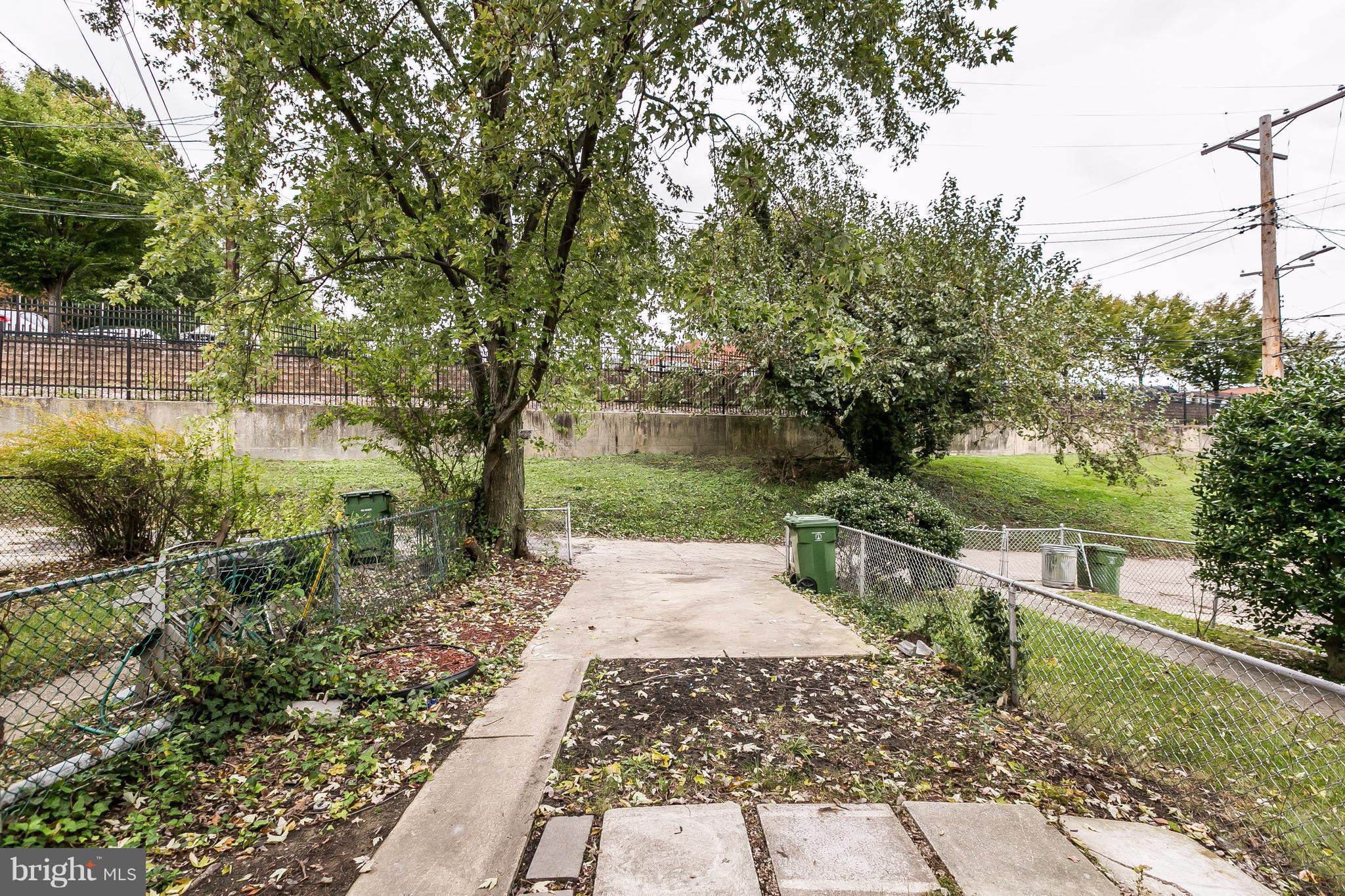 4016 Rexmere Road Baltimore, MD 21218 - Photo 21 of 26 a view of a yard with plants and a large tree