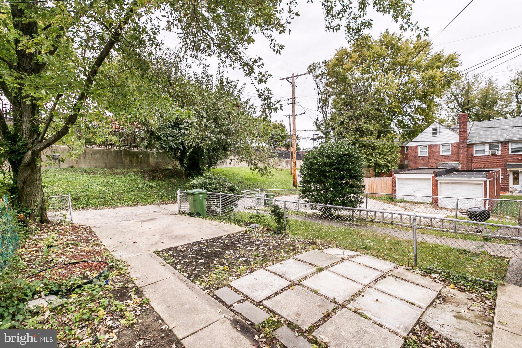 4016 Rexmere Road Baltimore, MD 21218 - Photo 22 of 26 a view of a yard with plants and a bench in front of house
