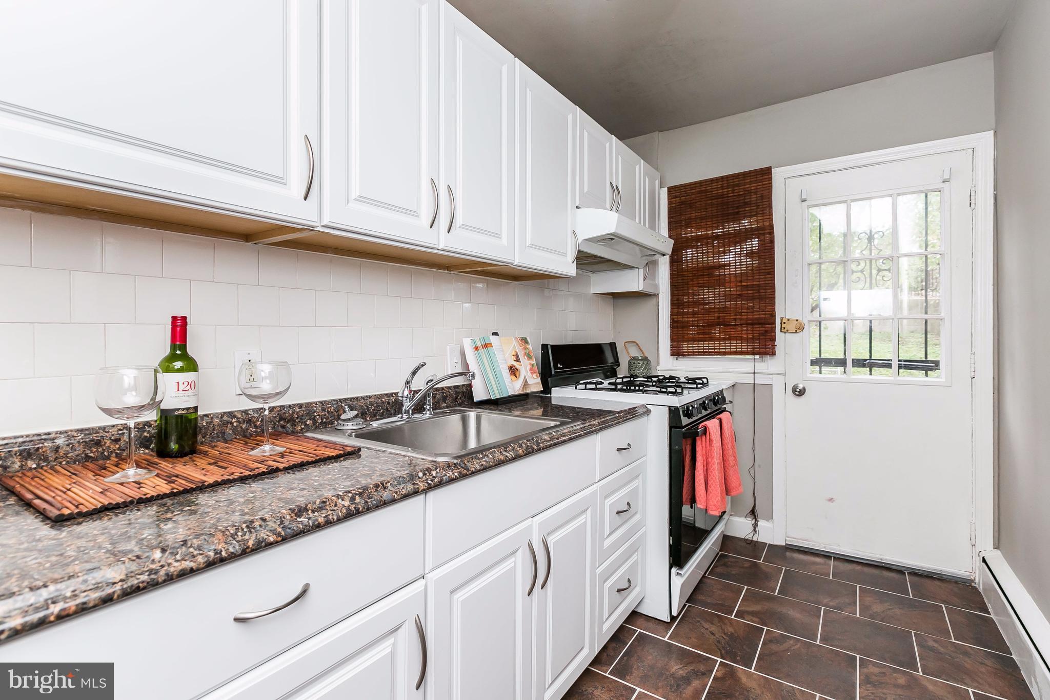 4016 Rexmere Road Baltimore, MD 21218 - Photo 6 of 26 a kitchen with sink cabinets and window