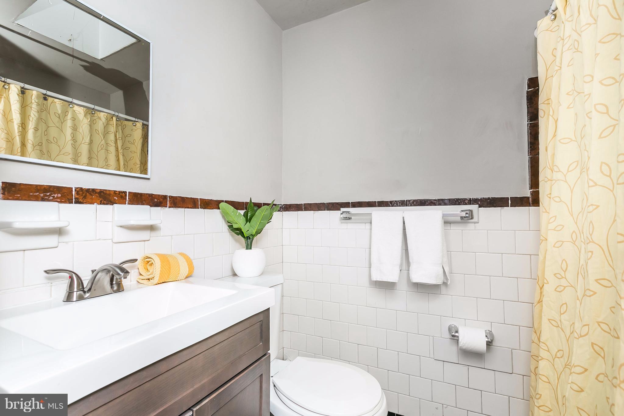4016 Rexmere Road Baltimore, MD 21218 - Photo 10 of 26 a bathroom with a sink toilet and mirror