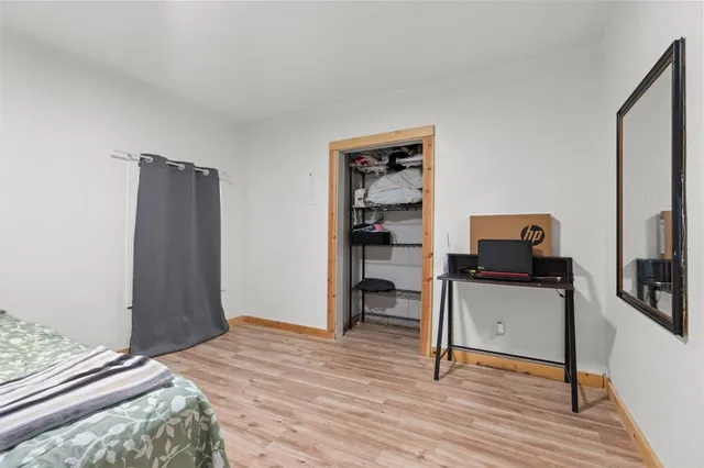 a bedroom with a bed and a computer on a table