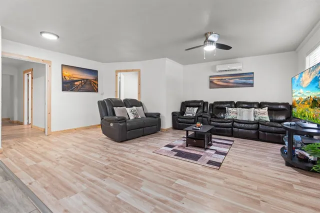a living room with furniture and wooden floor