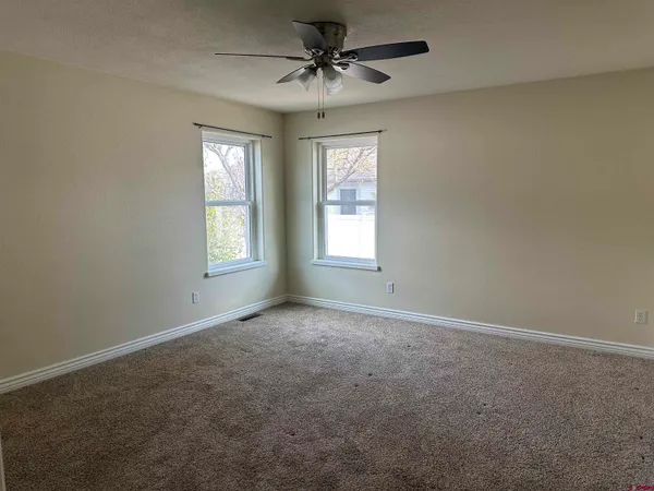 a bedroom with a bed next to a window and a chandelier