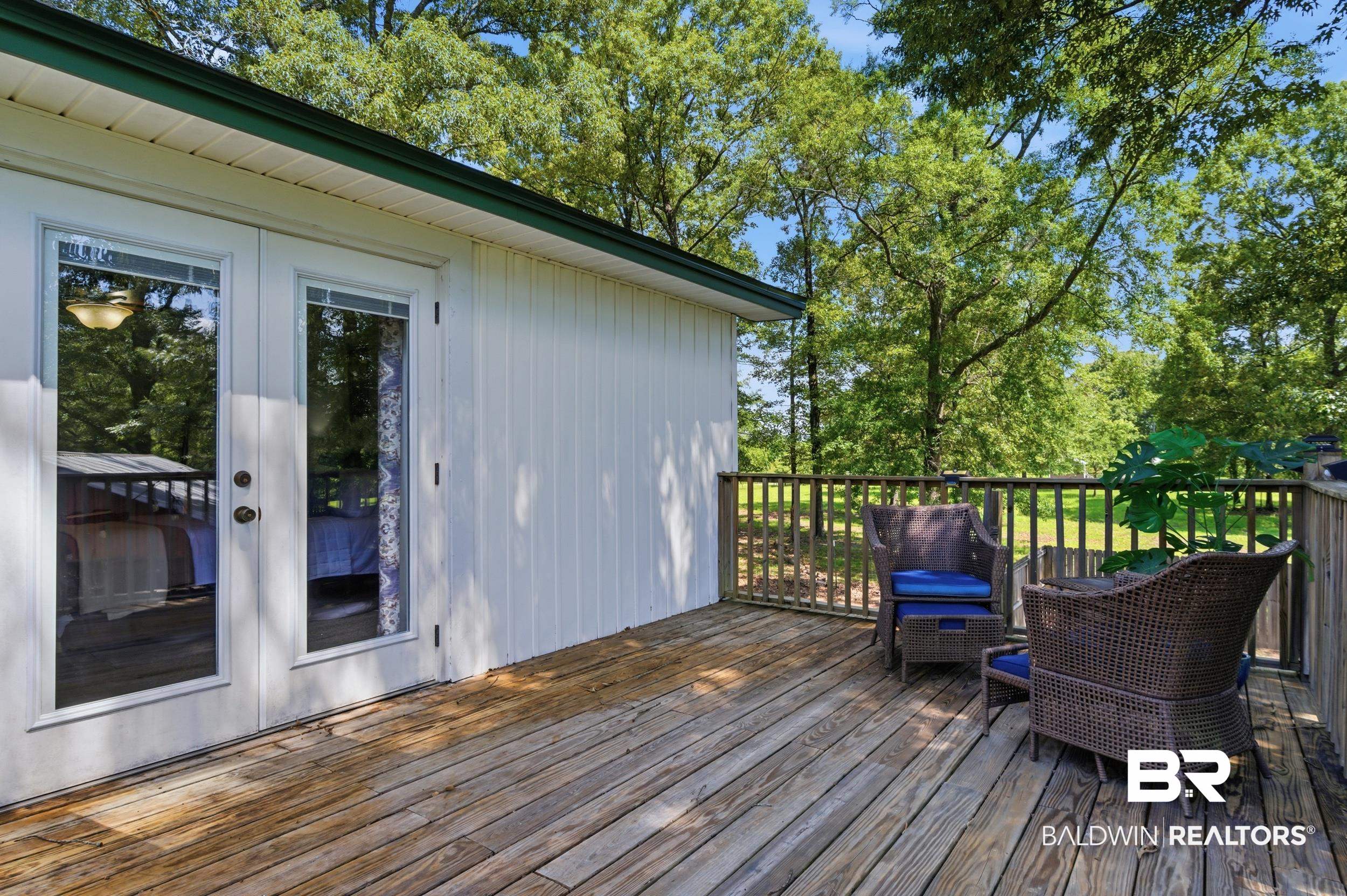 51620 Robert White Road Bay Minette, AL 36507 - Photo 63 of 81 Expansive wooden deck with a slatted railing, white vertical siding, and double glass-paned doors