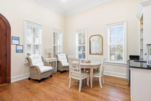 a kitchen with kitchen island granite countertop a table chairs refrigerator and microwave