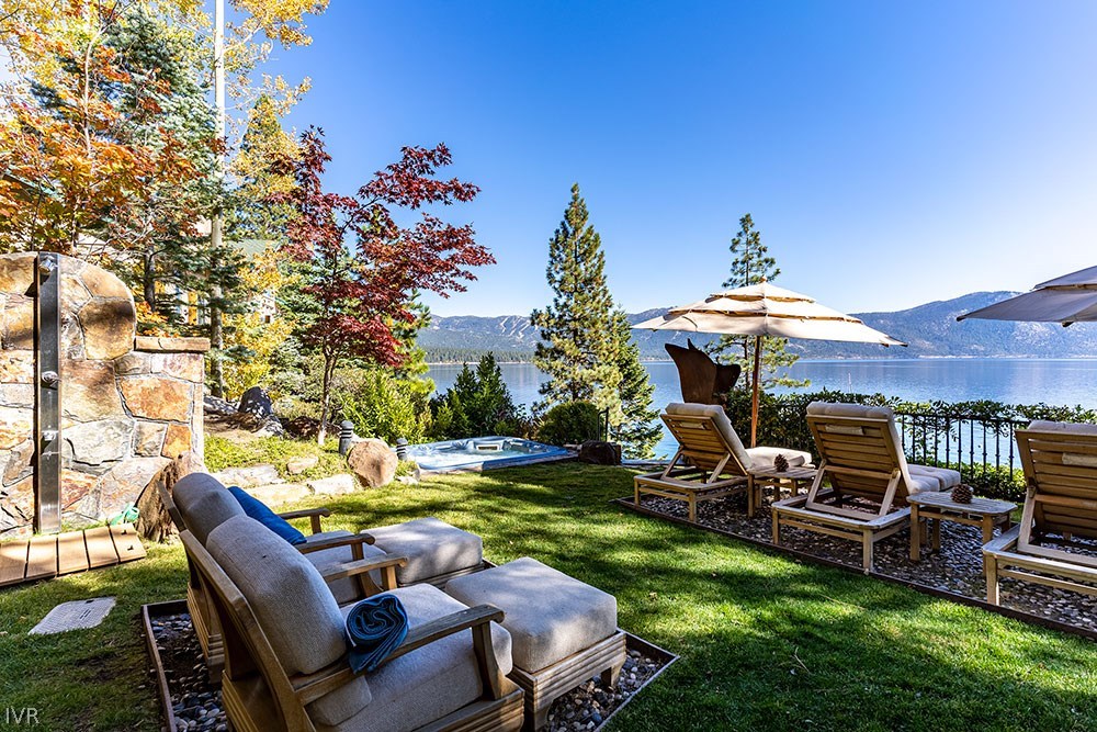 444 Gonowabie Road Crystal Bay, NV 89402 - Photo 29 of 35 a view of a backyard with table and chairs under an umbrella with a fire pit and a yard