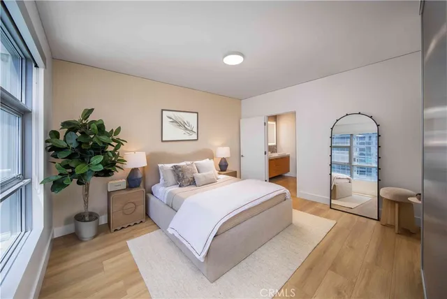 a bedroom with a large bed and a potted plant