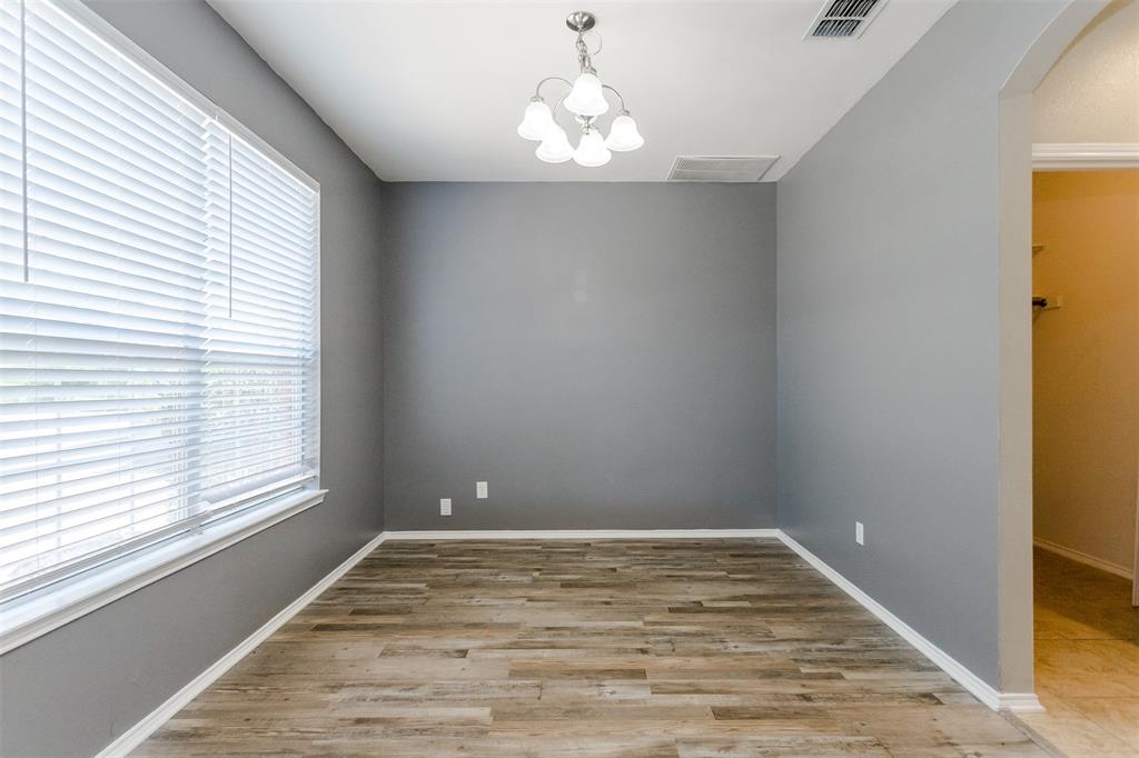 203 Arabian Road Waxahachie, TX 75165 - Photo 10 of 24 Spacious room featuring wood-finish flooring, neutral gray walls, and white baseboards