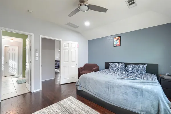 a bedroom with a bed and wooden floor