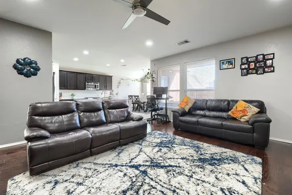 a living room with furniture and a ceiling fan