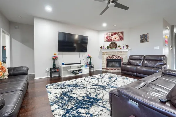 a living room with furniture a flat screen tv and a refrigerator