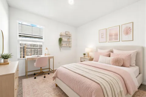 a bedroom with a bed a table and chair with a bookshelf