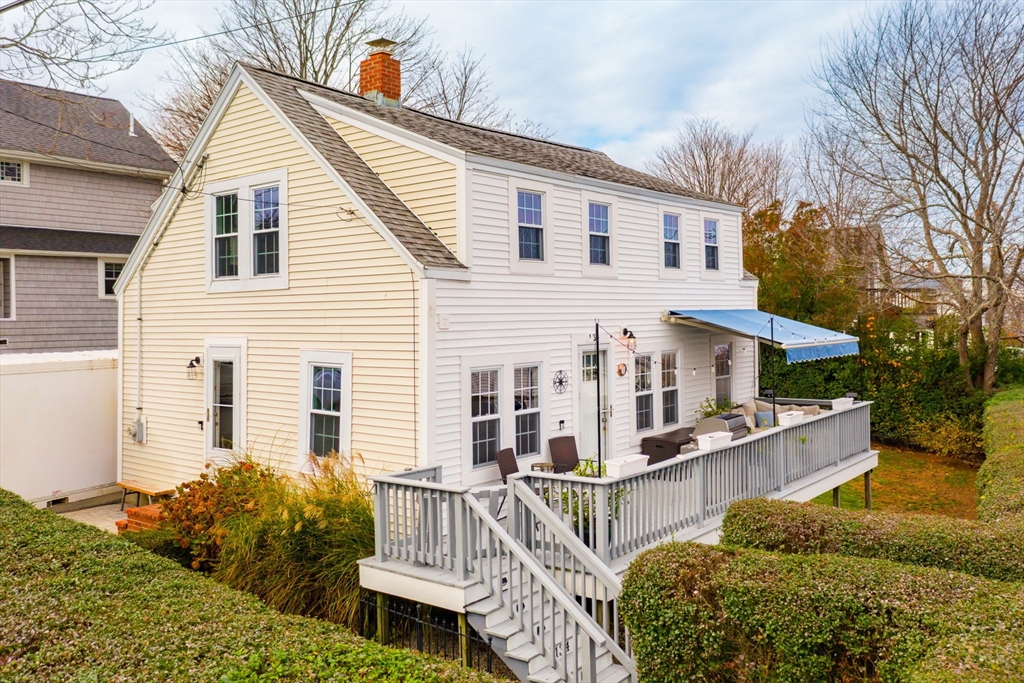 a view of a house with wooden deck front of house