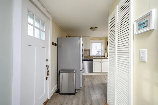 a kitchen with stainless steel appliances granite countertop a refrigerator a sink a stove and white cabinets