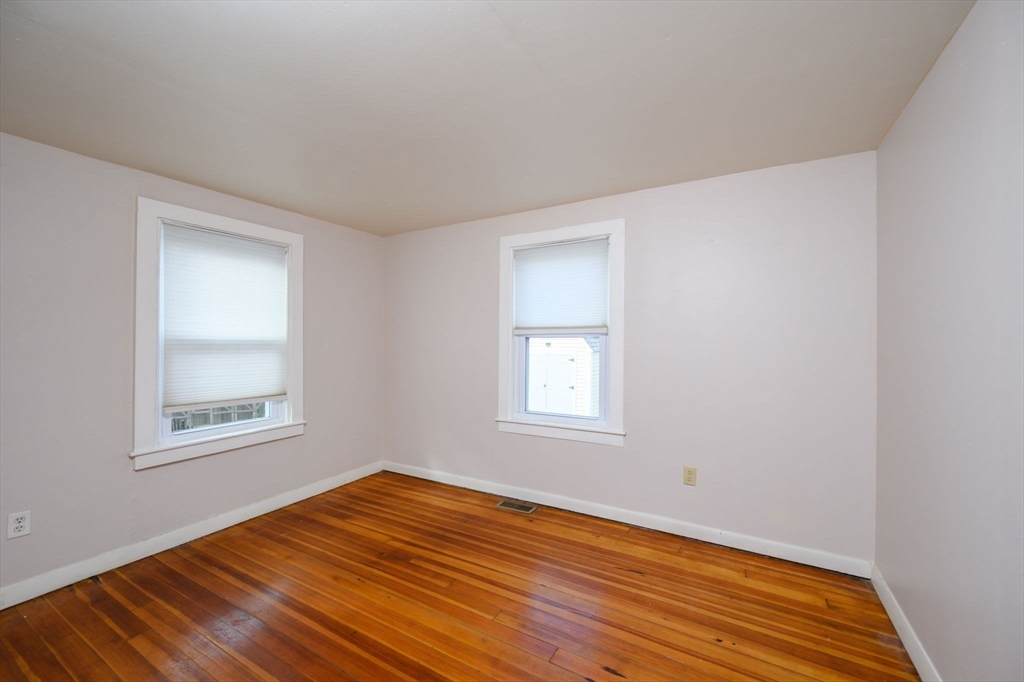 134 Hampton Circle Hull, MA 02045 - Photo 19 of 41 a view of an empty room with wooden floor and a window