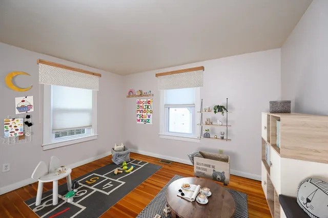 a view of bedroom with window and wooden floor