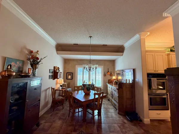 a kitchen with a sink a refrigerator and chairs