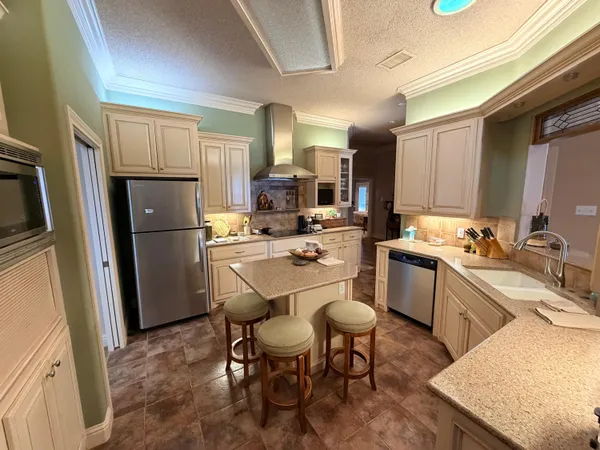 a kitchen that has a lot of cabinets in it and stainless steel appliances