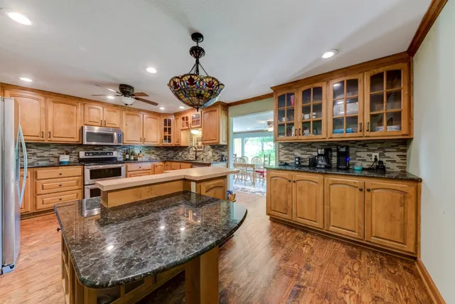 a kitchen with granite countertop a sink stainless steel appliances and counter space