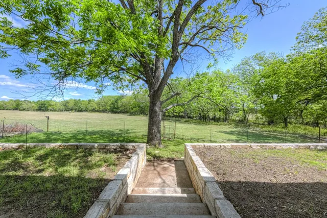 a view of a patio with table and chairs and potted plants